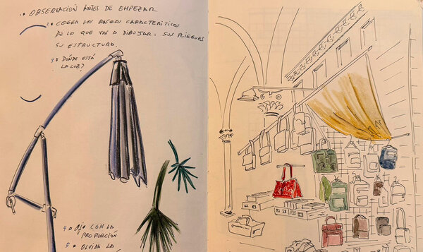 An open notebook showing two pencil sketches, one of a lamp and the other of designer handbags