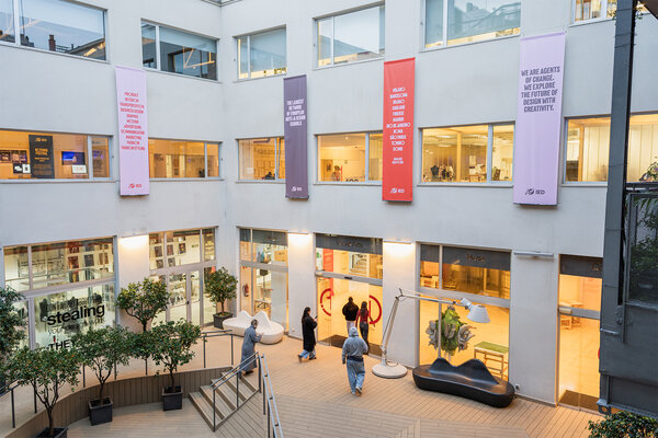 Interior of an educational center with a courtyard with plants, stairs and banners