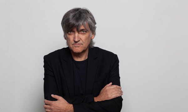 Medium shot of a middle-aged man looking at the camera with his arms crossed