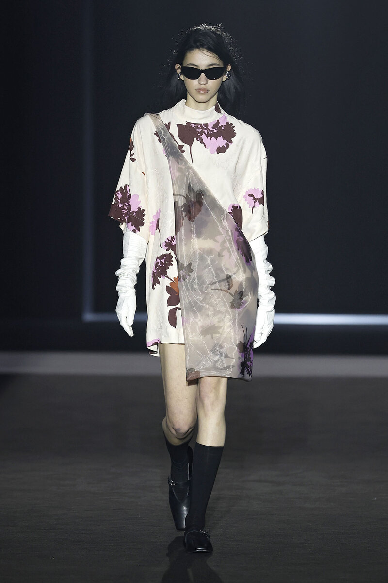 Model parading in a vaporous floral print dress by designer EIKO AI at 080 Barcelona Fashion (April 2025)