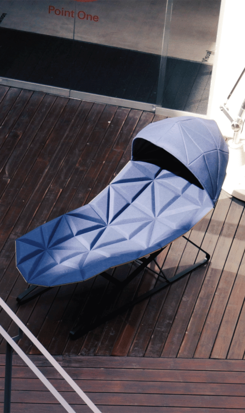 Blue fabric padded chaiselongue with a large canopy on a terrace