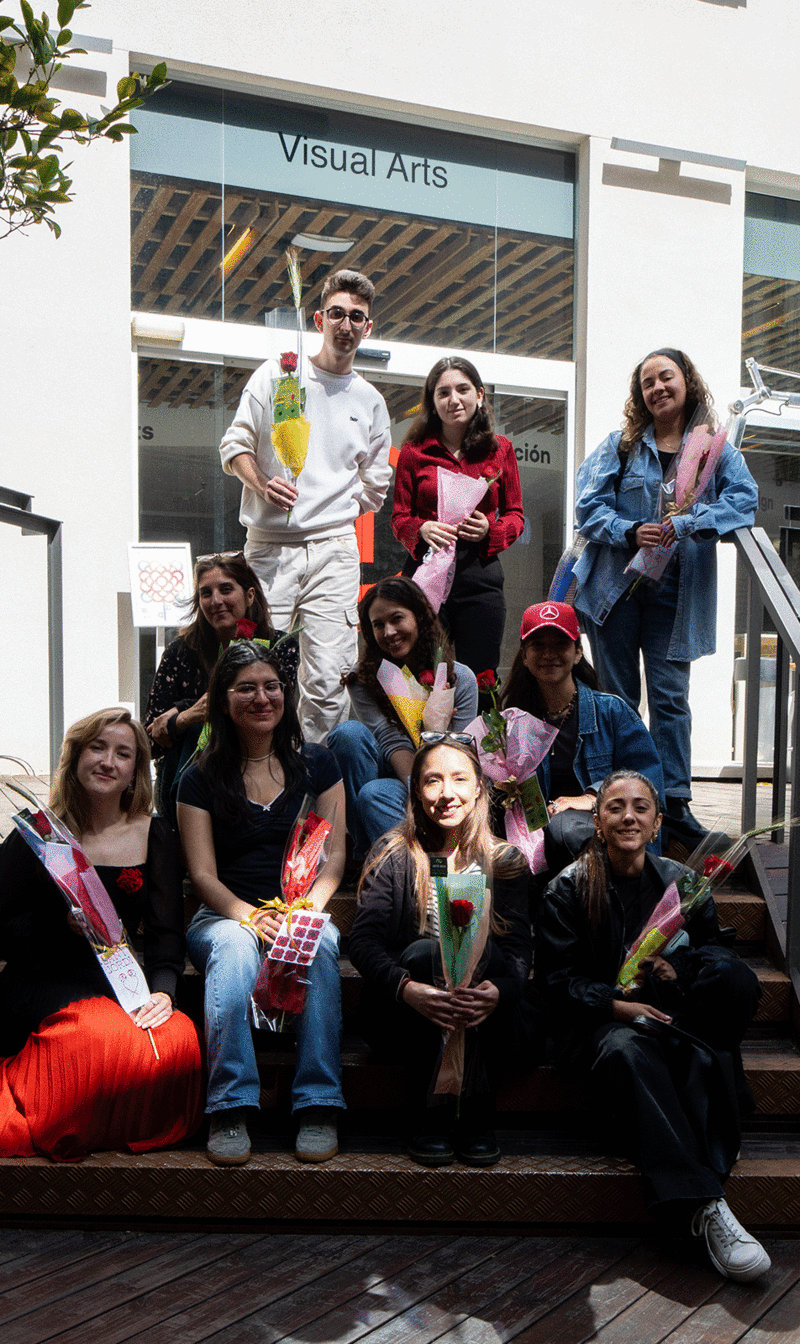 A group of students pose seated on the steps of the IED Barcelona courtyard with the Sant Jordi roses ready to deliver to three senior citizen homes in the Gràcia neighborhood.