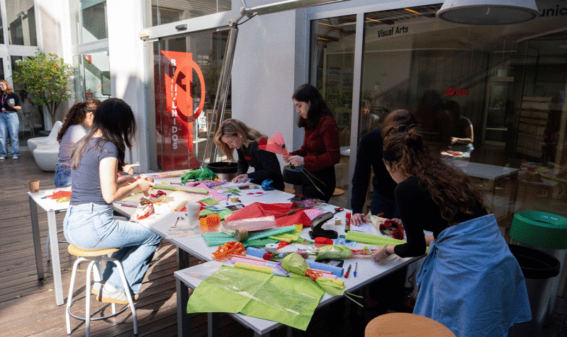 A group of students designing greeting cards to add to the Sant Jordi Roses in the entrance courtyard of the IED Barcelona