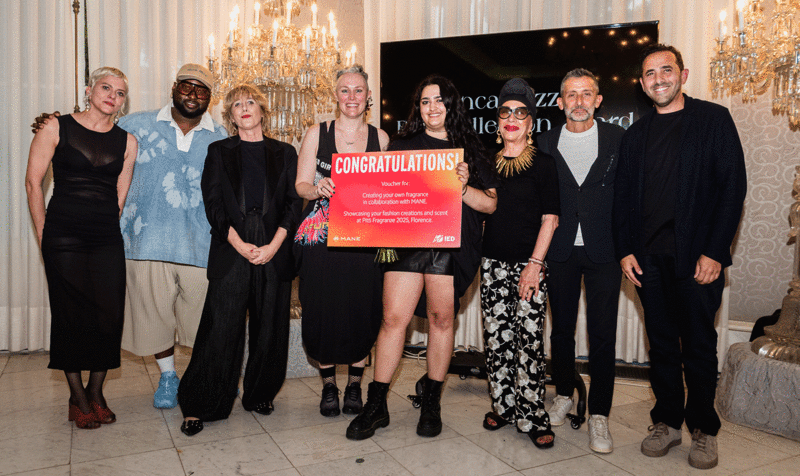 Awards ceremony with the winner in the center and jury members on the sides in front of a screen