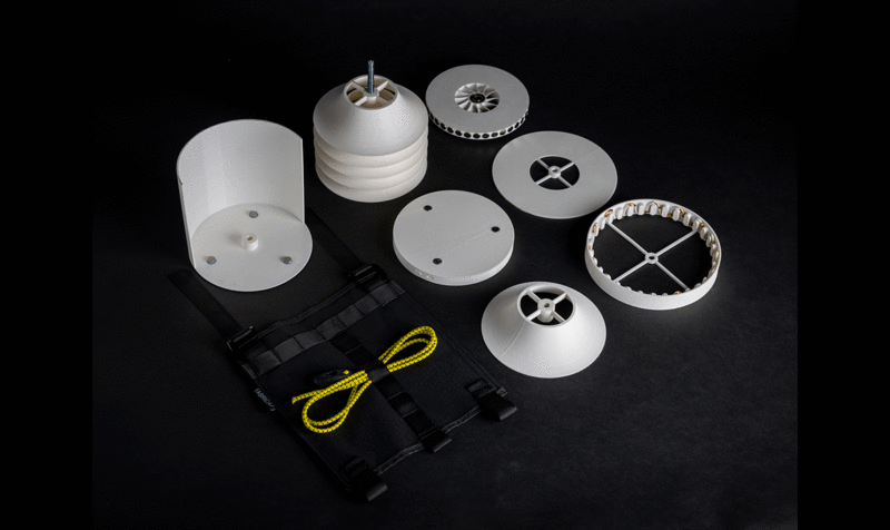 Several white, round pieces of a disassembled device on a black background