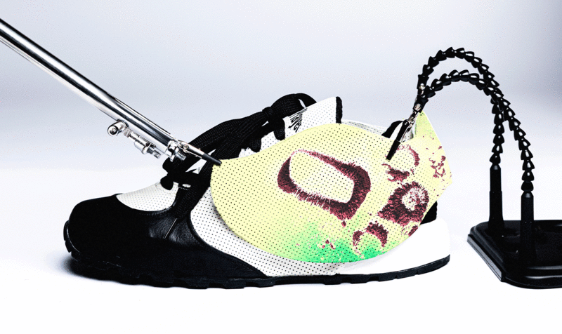 Sports shoes seen on the side in black and white and with a yellow accessory that customizes it