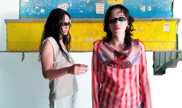 Photocomposition with two women wearing colorful clothes on a drawn background and with a mask painted over their eyes
