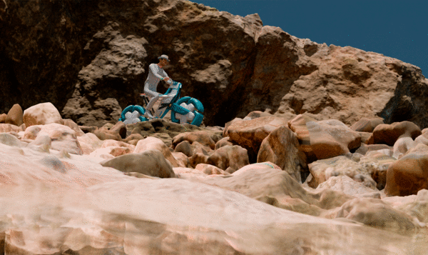 Motorcyclist on an amphibious motorcycle in a beach and rocky landscape