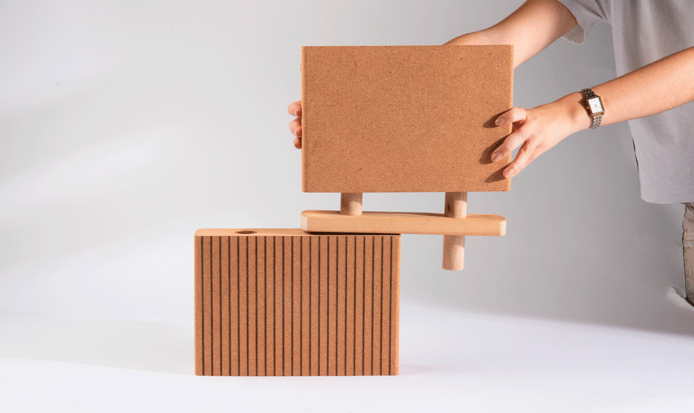 Two interlocking cork panels held by a person whose arms we only see on a white background