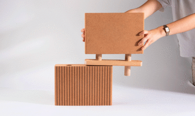 Two interlocking cork panels held by a person whose arms we only see on a white background