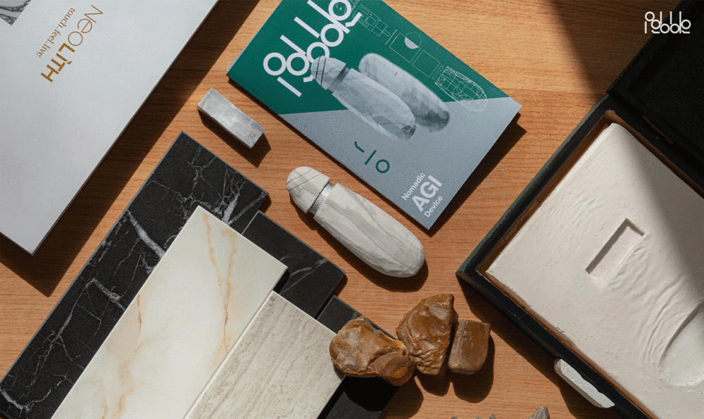 Close-up of an office desk with documents arranged neatly diagonally and a white AIG device shaped like a flint point and stone texture in the center.