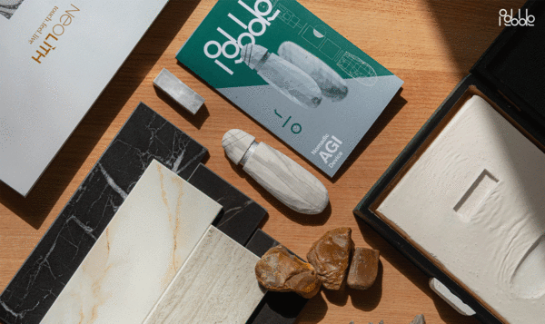 Close-up of an office desk with documents arranged neatly diagonally and a white AIG device shaped like a flint point and stone texture in the center.