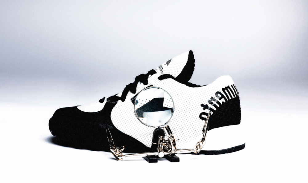A sports shoe seen from the side with black and white motifs
