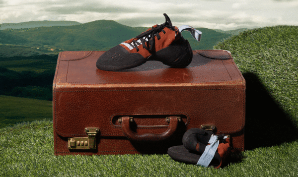 Climbing shoe on an old suitcase in a green meadow